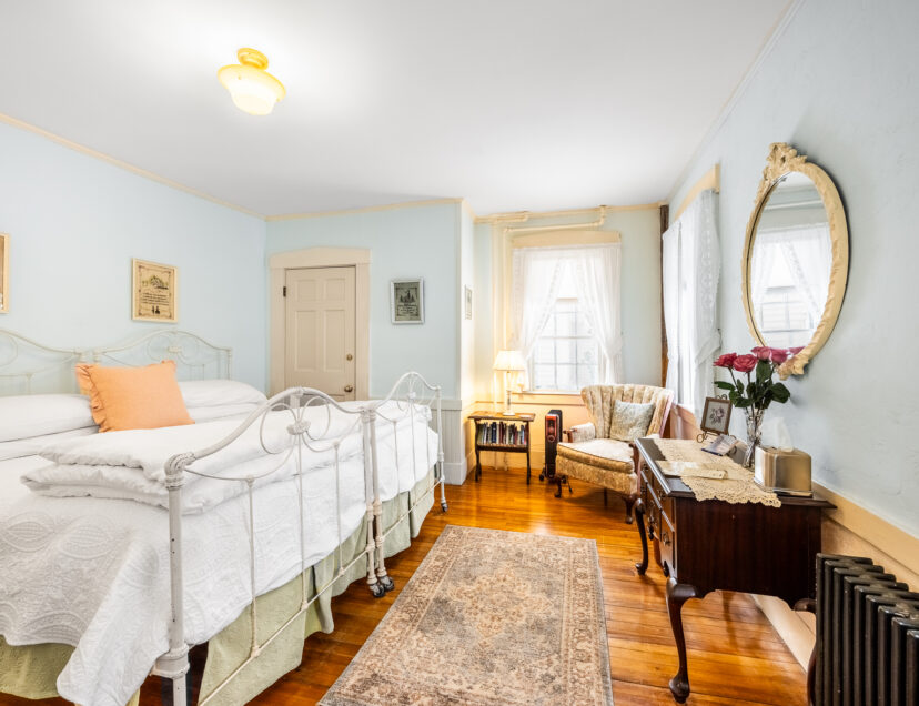 Room 1 with hardwood floors a blue area rug and a seating area for two