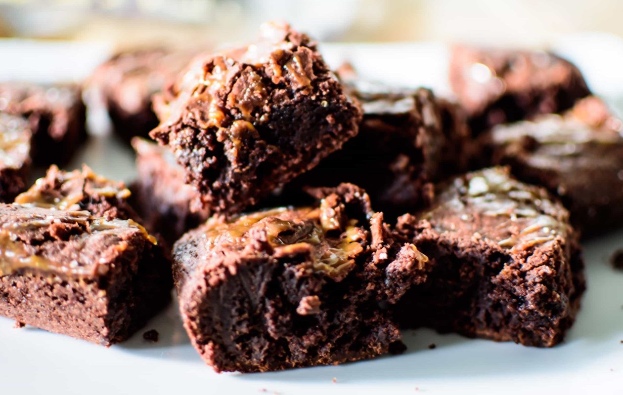 A plate of brownies with chopped nuts