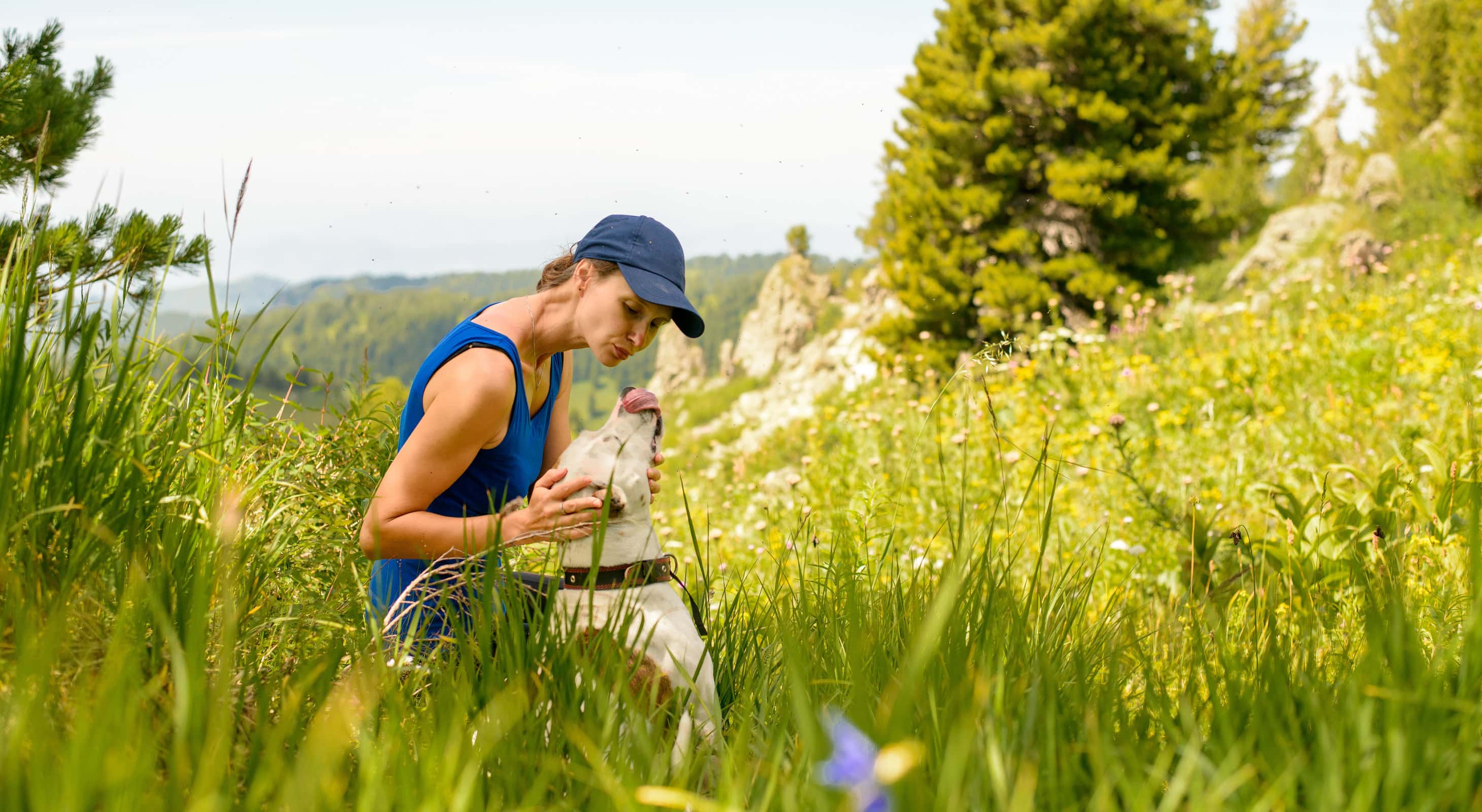 Lady and her dog on a hill in the wilderness
