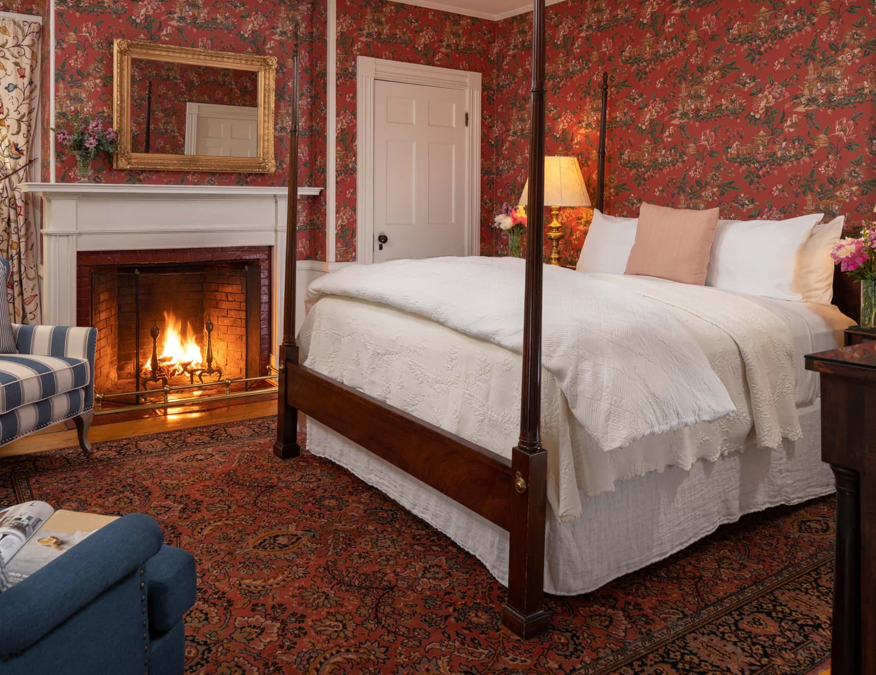 Room 10 with a king-size bed and a fireplace with a large area rug and seating area for two
