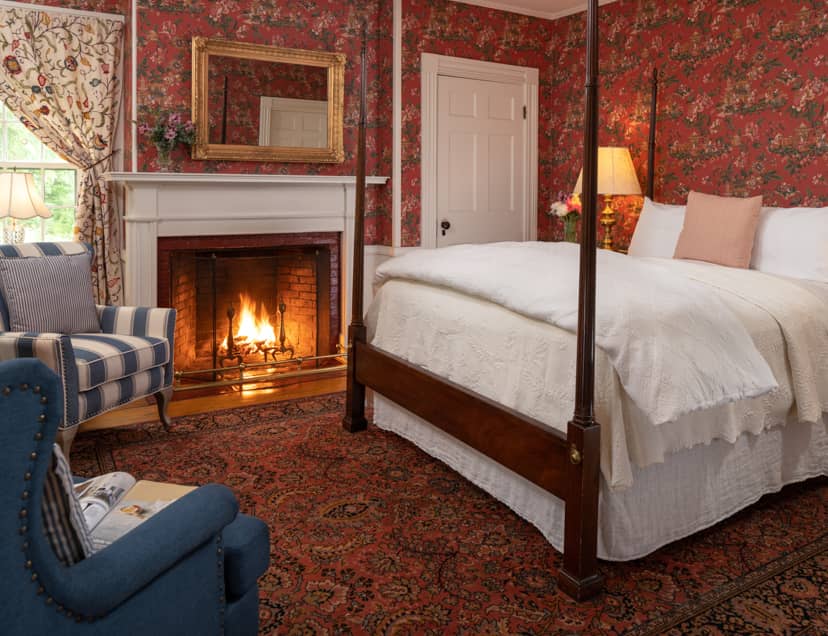 Room 10 with a king-size bed and a fireplace with a large area rug and seating area for two