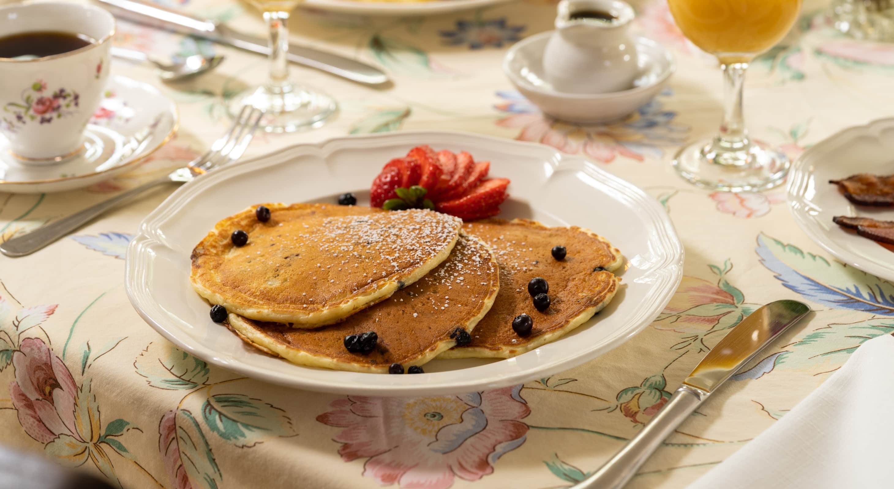 blueberry pancakes served with fresh cut strawberries
