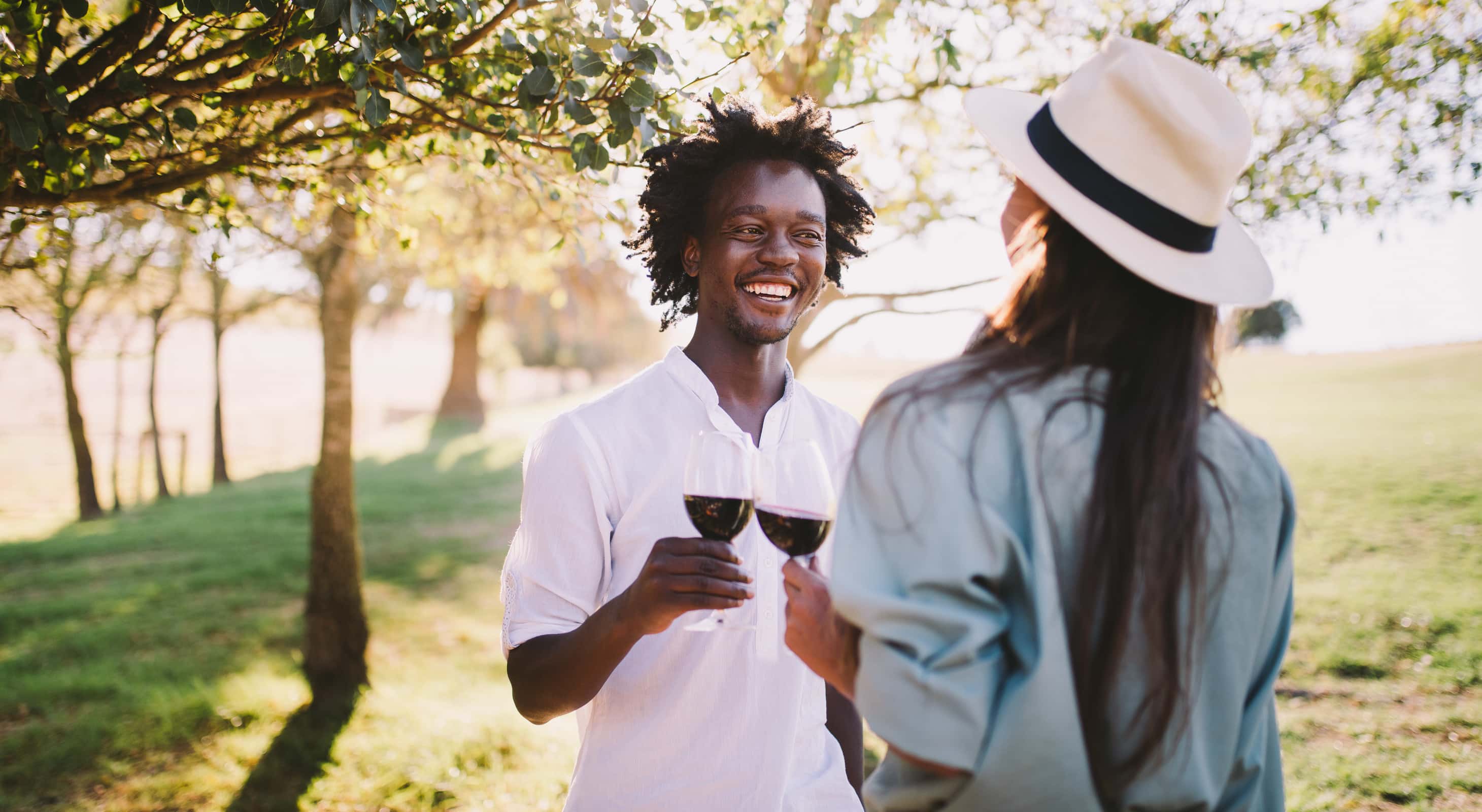 Two friends hanging out drink wine outdoors