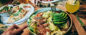 healthy dinner plated with two people sharing it as they fork a bite 