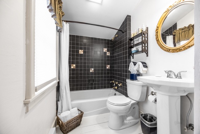 Room 11 bathroom with a sink and mirror and a tub/shower combination