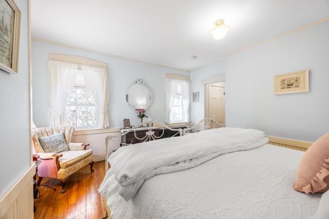 Room 1 with a chair, a small writing desk and large windows