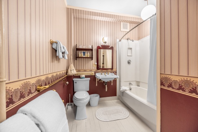 Room 10 bathroom with a sink and mirror and a tub/shower combination