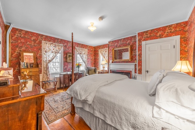 Room 10 with a king-size bed and a fireplace with a large area rug and seating area for two