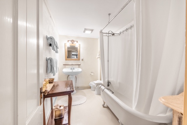 Room 4 bathroom with sink, mirror, and clawfoot tub with shower