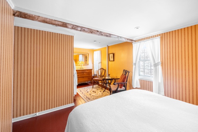 Room 7 with a queen bed, seating area and dresser