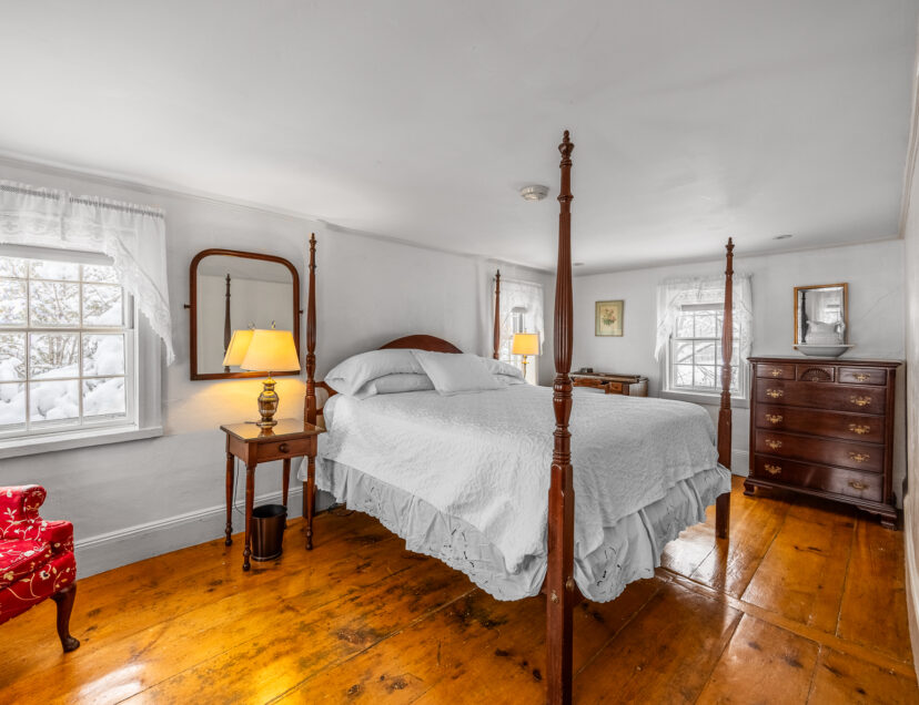 King size four poster bed with dresser, desk and windows