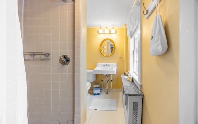 Room 8 bathroom with a large window sink and mirror and a shower