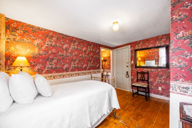 Room 2 twin bed seating area with chair and mirror