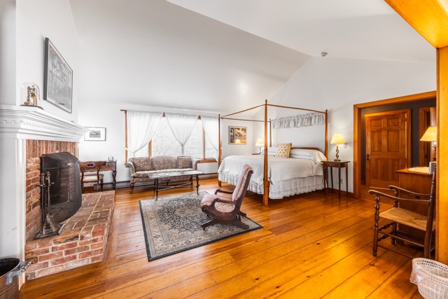 Kind size four poster bed with sitting area and area rug